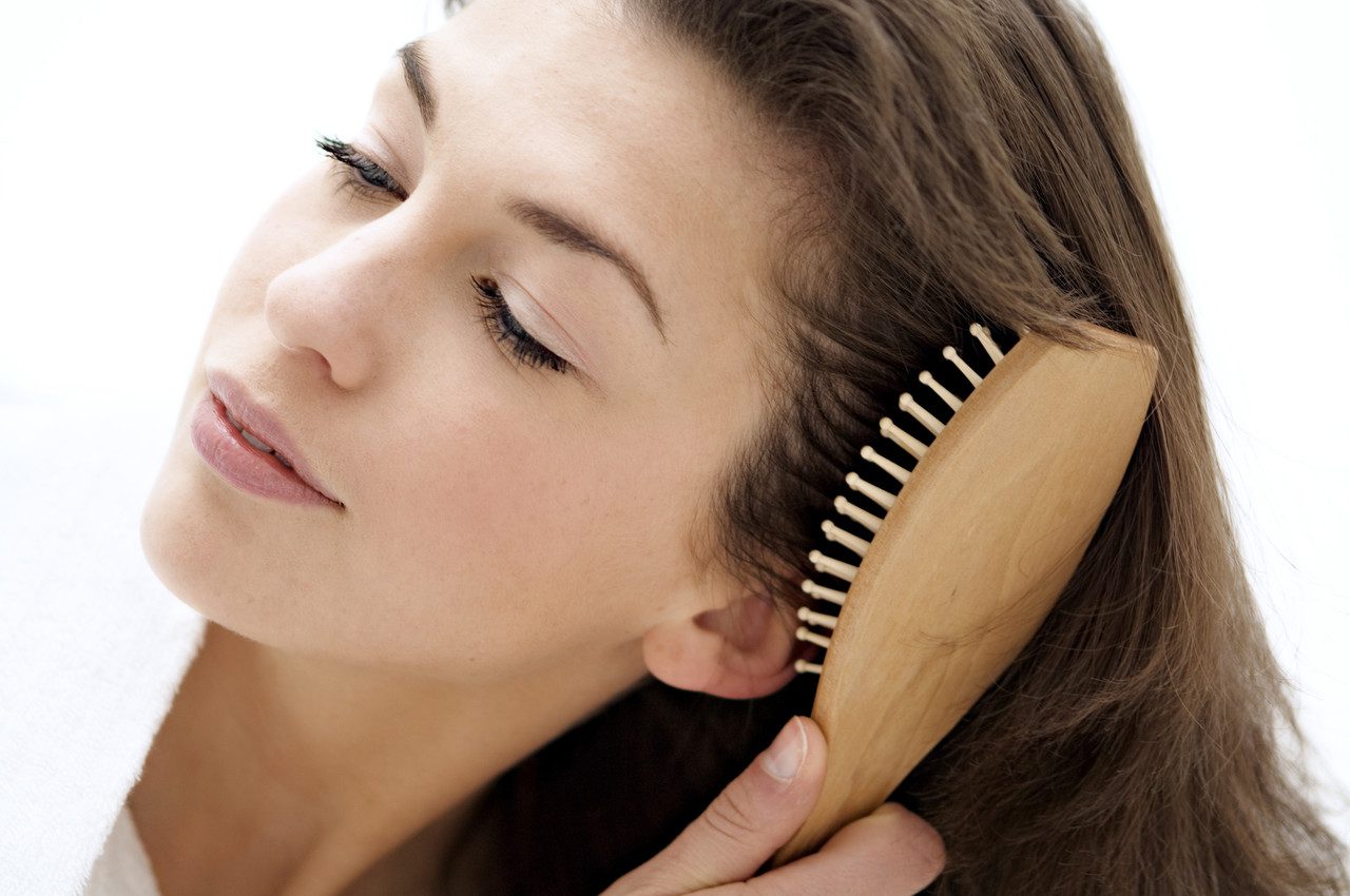 Portrait of a young woman brushing her hair --- Image by © A. Chederros/Onoky/Corbis